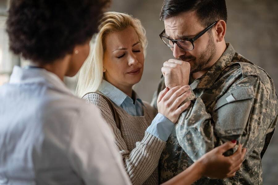 female doctor comforting crying veteran his wife after receiving bad news medical clinic focus is soldier Military Divorce: Understanding Unique Rights